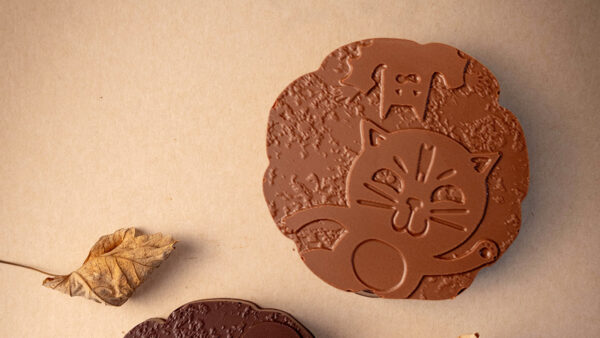 Palet chauve souris au chocolat au lait, disque pate d'amande, cerise confite, praliné amande et noix caramélisé imaginé par Julien Dechenaud.