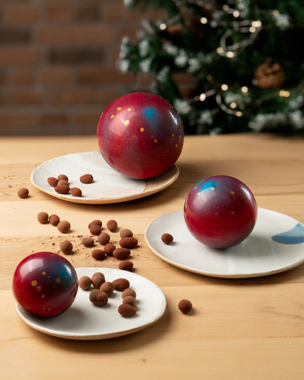 Boules de noël 2025, en version chocolat au lait et chocolat noir, garnie d'amandes et noisettes enrobées. des créations signés Julien Dechenaud chocolatier à Paris.