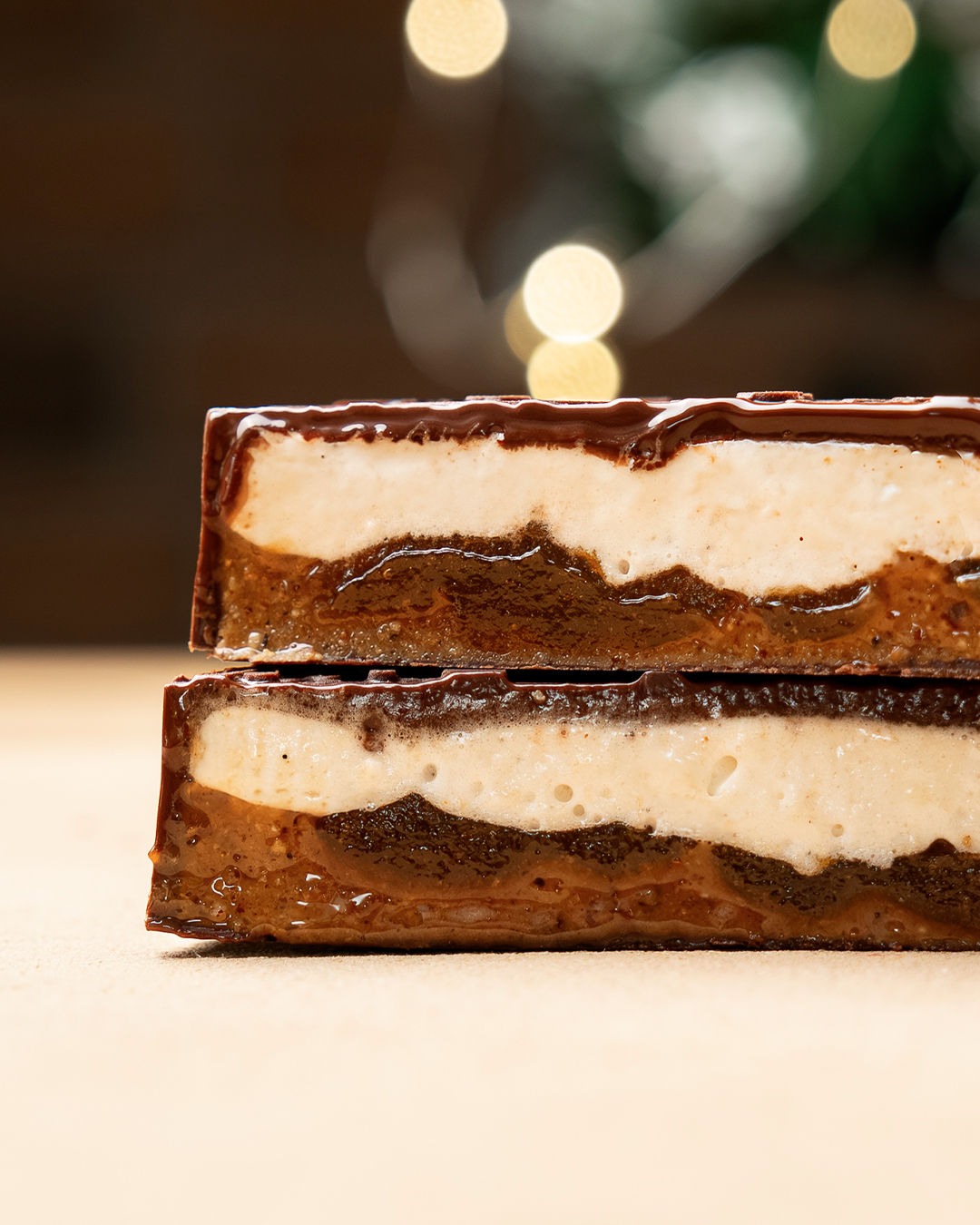 Découpe du médaillon flocon, guimauve vanille, confit d’abricot et praliné noisette, le tout enrobé de chocolat noir ou chocolat au lait. Une création noël 2025 par Julien Dechenaud artisan chocolatier à Paris.