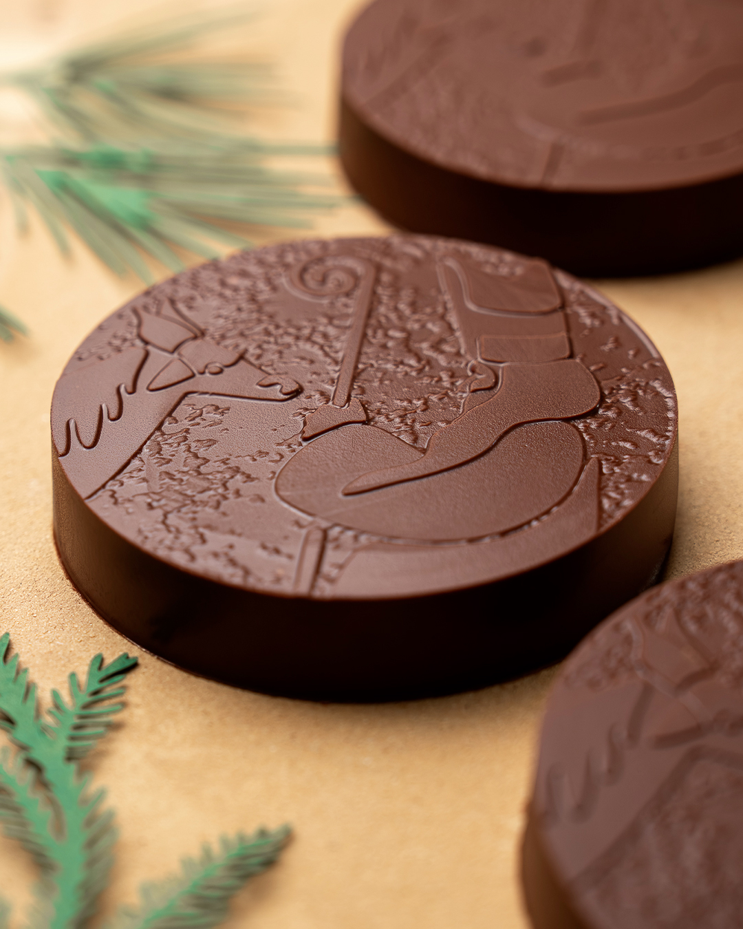 Palet St Nicolas au chocolat noir dévoile un cœur ganache vin Chaud et praliné amande. Collection de Noël 2025 par Julien Dechenaud Chocolatier à Paris.