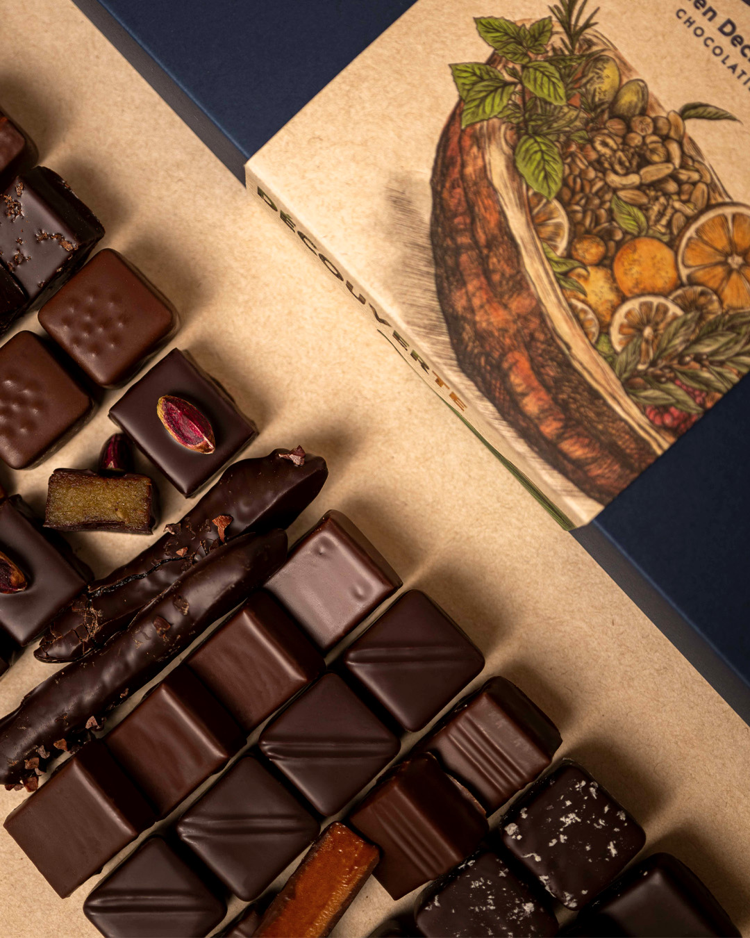 Crop sur la boite découverte de 44 chocolats : ganaches pures origines, ganaches parfumées, pralinés amande, noisette et citronettes composent cet assortiment, un coffret signé Julien Dechenaud chocolatier torréfacteur à Paris.