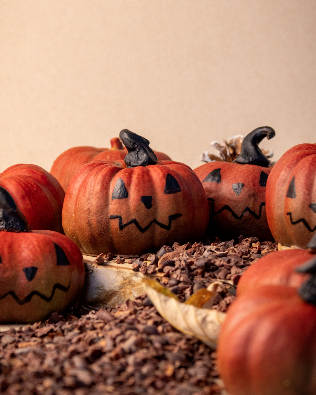Citrouilles d'halloween avec une coque en chocolat noir garnie de billes de céréales chocolat noir et chocolat au lait. Une création halloween imaginée par le chef Julien Dechenaud chocolatier.