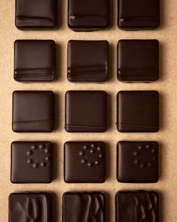 Focus sur les ganaches pur origines au chocolat noir, chaque bonbons de chocolat à son décors: Madagascar, Ghana, Jamaïque, Venezuela, Pérou…