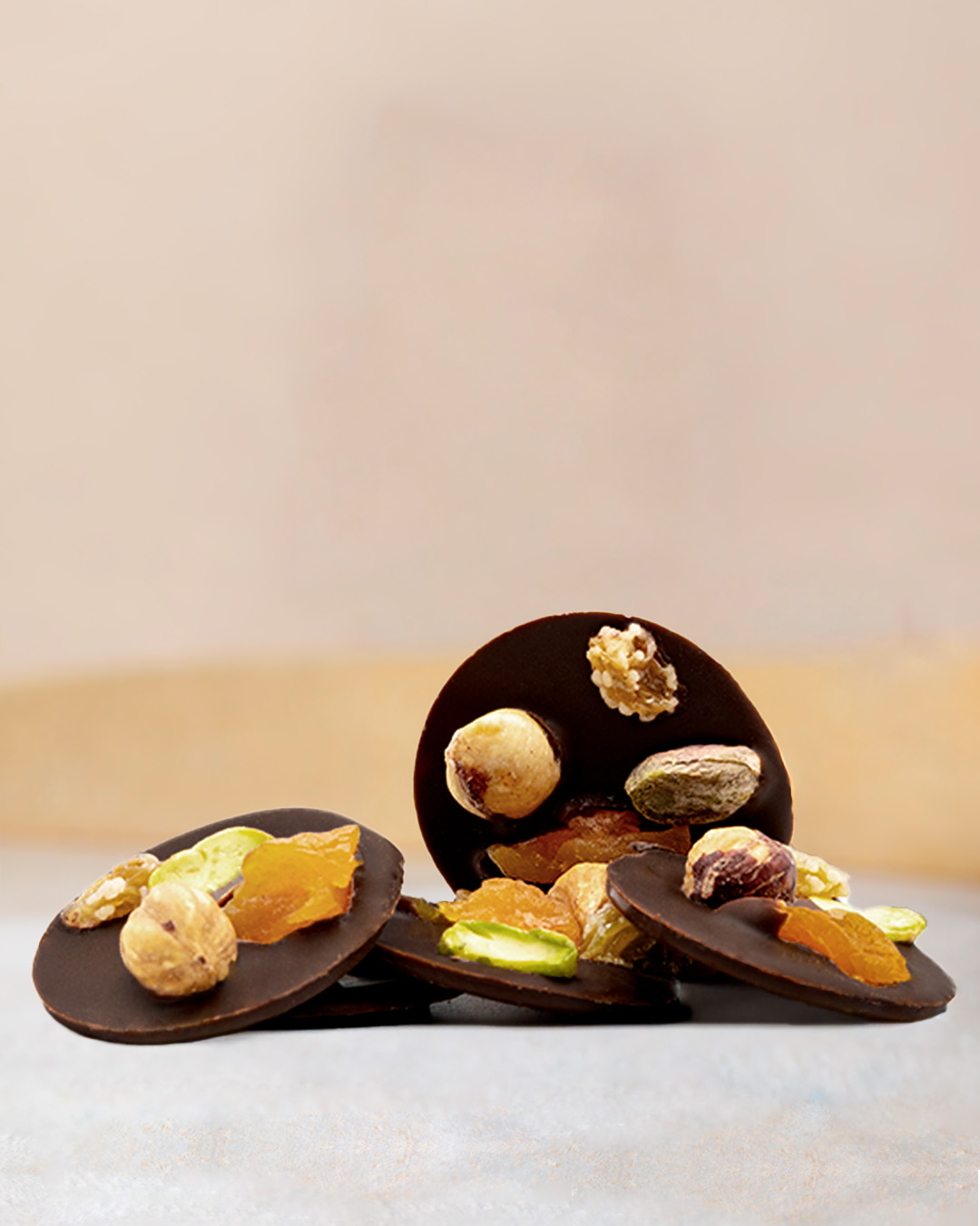 Sachet de mendiants au chocolat noir. Palets de chocolat noir è0% Cameroun et noisettes, pistaches et fruits secs.