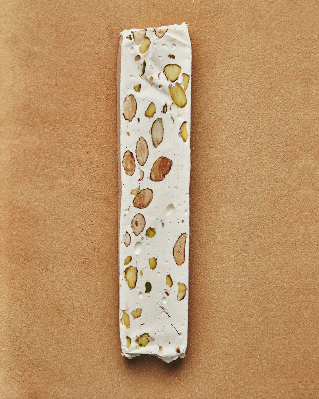 Morceau de nougat blanc au miel, amandes, pistaches et vanille. Une création du chef Julien Dechenaud chocolatier torréfacteur à Paris et Vincennes.