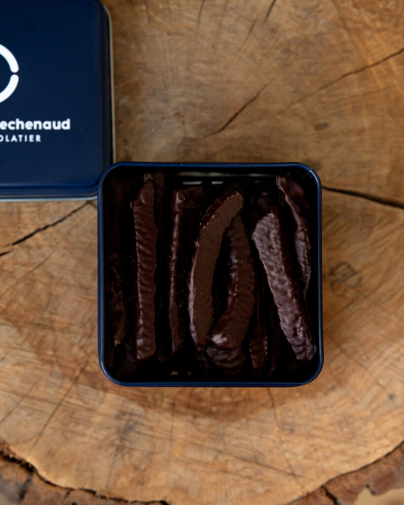 Boite métallique de fines lamelles d’orange de Calabre, enrobées de chocolat noir 70% Cameroun. Accordez vous une pause gourmande et acidulée avec nos orangettes du chef Julien Dechenaud chocolatier torréfacteur.