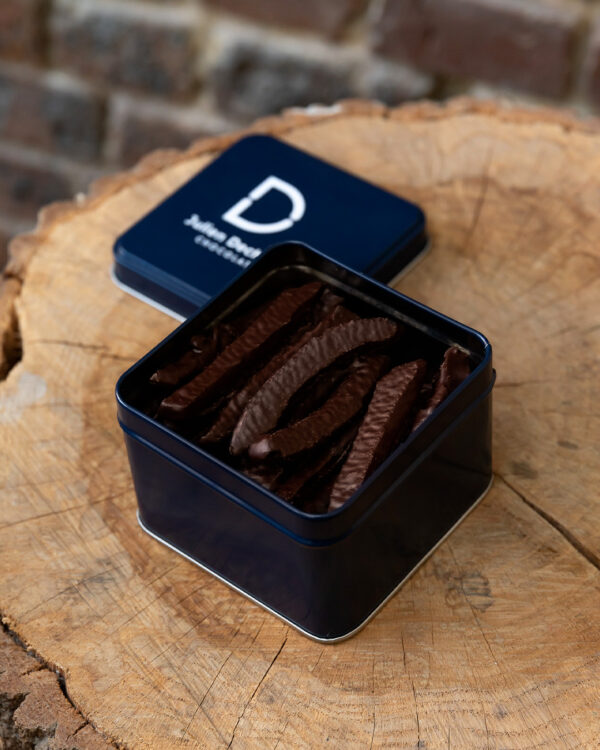Boite métallique de fines lamelles d’orange de Calabre, enrobées de chocolat noir 70% Cameroun. Accordez vous une pause gourmande et acidulée avec nos orangettes du chef Julien Dechenaud chocolatier torréfacteur.
