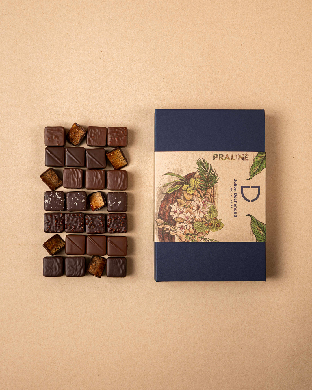 Boite de 28 pralinés au chocolat noir et lait : amande, noisette, coco et amande-noisette feuilleté, un assortiment gourmand et hautement savoureux imaginé par le chef Julien Dechenaud chocolatier à Paris et Vincennes.