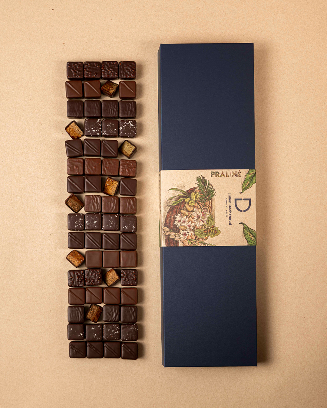 Boite de 68 pralinés au chocolat noir et chocolat au lait : amande, noisette, coco, pistache, cacahuète et amande-noisette feuilleté, un assortiment gourmand et hautement savoureux imaginé par le chef Julien Dechenaud chocolatier à Paris et Vincennes.