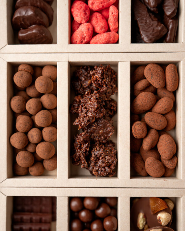 Focus sur le coffret gourmandises : dragées amandes et noisettes, rochers, pralines roses...